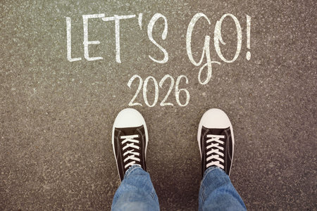 New Year. Man standing in front of the phrase Let's Go! and numbers 2026 on asphalt, top view