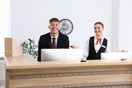 Receptionist and hostess working at reception desk in hotelの写真素材