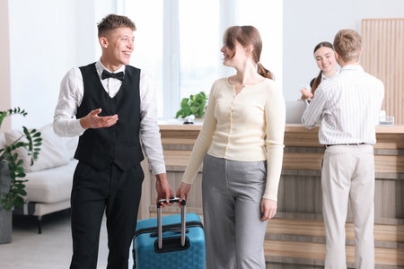 Receptionist assisting guest at reception in hotelの写真素材