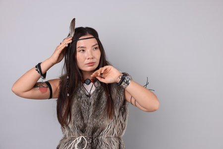 Shaman woman in feather headdress on light gray background, space for textの写真素材