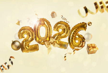 Happy New 2026 Year. Golden balloons in shape of numbers, gift boxes and festive decor against beige background. Greeting or invitation card designの写真素材