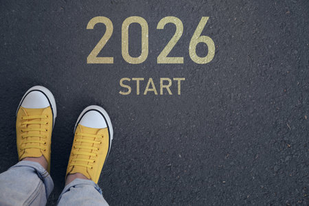 New Year. Woman standing in front of word Start and numbers 2026 on asphalt, top viewの写真素材