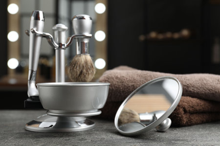 Metal stand with barber's tools, towels and mirror on gray textured table in barbershop, closeupの写真素材