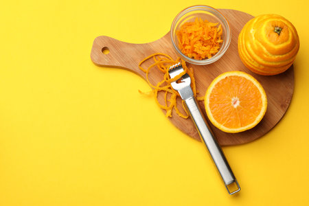 Orange zest, fresh fruits and zester tool on color background, top view. Space for textの写真素材