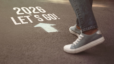 New 2026 Year. Man walking toward arrow with numbers and phrase Let's Go! on asphalt, closeupの写真素材