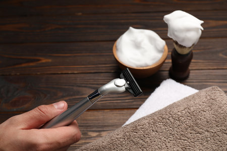 Barber with tools at wooden table, closeup. Space for textの写真素材