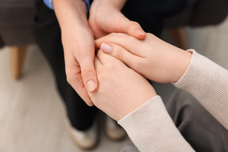 Psychologist supporting woman during therapy session indoors, closeupの写真素材