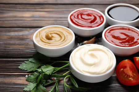 Different sauces and herbs on wooden table, closeupの写真素材