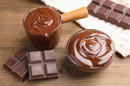 Melted chocolate and pieces on wooden table, closeupの写真素材