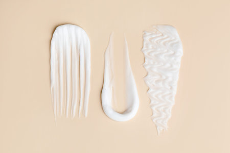 Samples of different cosmetic products on beige background, flat lay