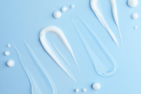 Samples of different cosmetic products on light blue background, flat layの写真素材