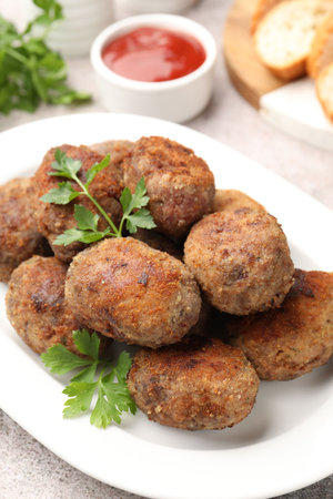 Tasty meat patties served on gray table, closeup