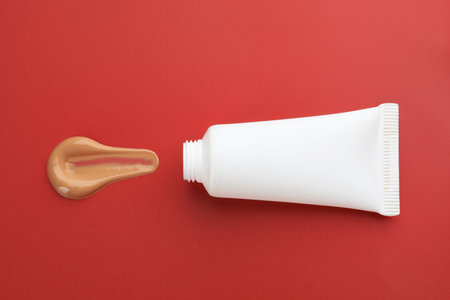 Tube with foundation on red background, top viewの写真素材