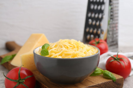 Grated and pieces of cheese, tomatoes, basil on table, closeup. Space for textの写真素材