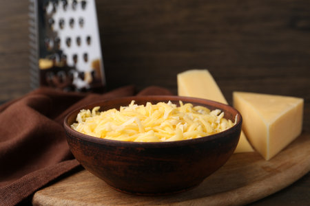Grated and pieces of cheese on wooden table, closeupの写真素材
