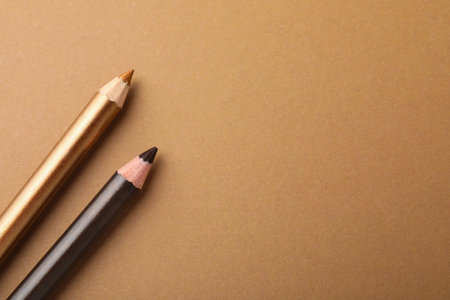 Pencils on brown background, flat lay. Space for textの写真素材