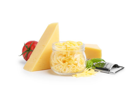 Grater, tomato, and pieces of cheese isolated on white