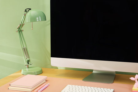 Stylish workplace with computer and pink mat on desk in office, closeupの写真素材