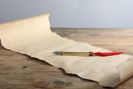 Old paper scroll and fountain pen on wooden table, closeupの写真素材