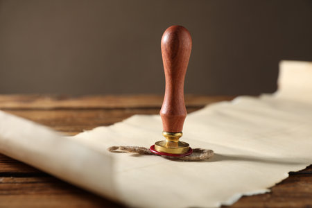 Old paper scroll and wax stamp on wooden table, closeupの写真素材