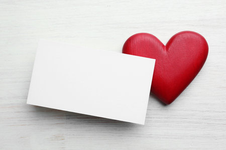 Blank card and decorative heart on white wooden table, top view. Mockup for designの写真素材