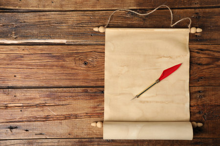 Old paper scroll and fountain pen on wooden table, top view. Space for textの写真素材