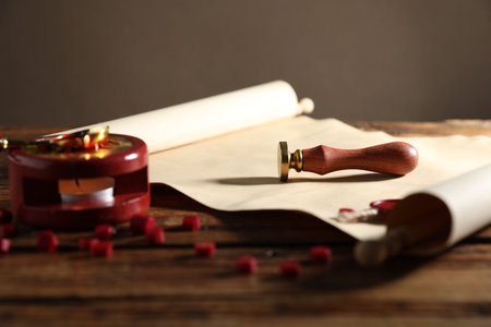 Old paper scroll, stamp and pieces of wax on wooden table, closeupの写真素材