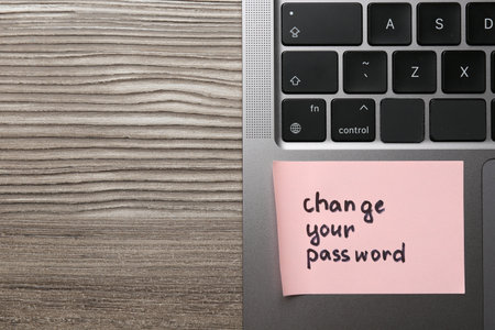Note with phrase Change your password and laptop on wooden desk, top view. Space for textの写真素材
