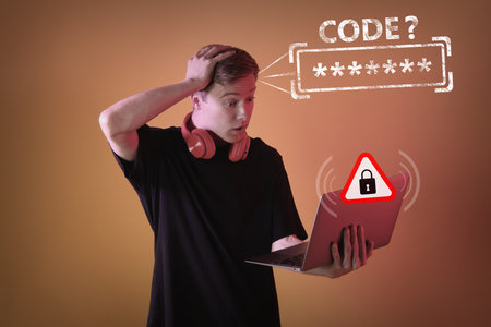 Shocked young man with laptop forgot password. Dark orange backgroundの写真素材