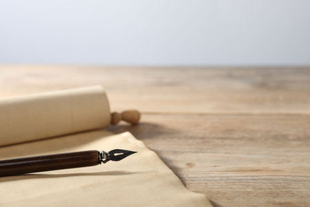 Old paper scroll and fountain pen on wooden table, closeupの写真素材