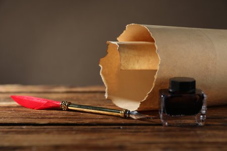 Old paper scroll, fountain pen and inkwell on wooden table, closeupの写真素材