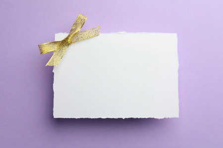 Blank card on violet background, top view. Mockup for designの写真素材