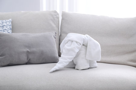 Cute elephant made with towel on sofa indoors, closeupの写真素材
