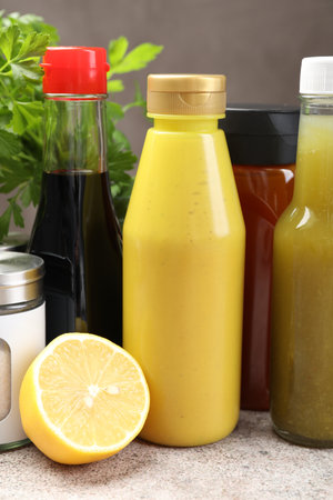 Bottles of different tasty sauces and products on gray table, closeupの写真素材