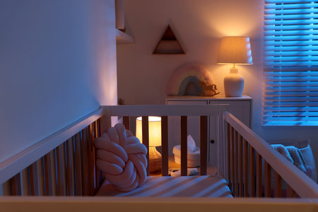 Stylish baby's room with crib and dresser at night. Interior designの写真素材