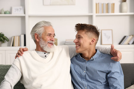 Father and son hugging on sofa at home