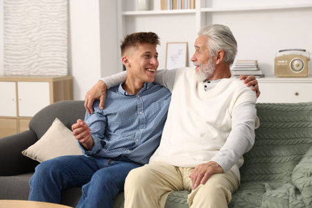 Father and son hugging on sofa at home