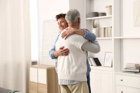 Father and son hugging each other at homeの写真素材