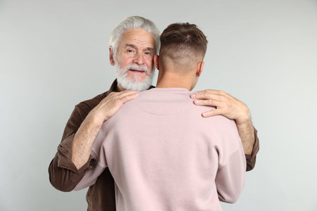 Father and son hugging on light gray backgroundの写真素材