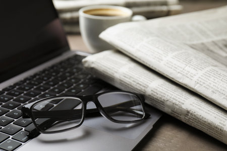 Newspapers, laptop and glasses on gray table, closeupの写真素材