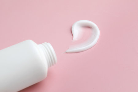 Sample of moisturizing cream and tube on pink background, closeupの写真素材