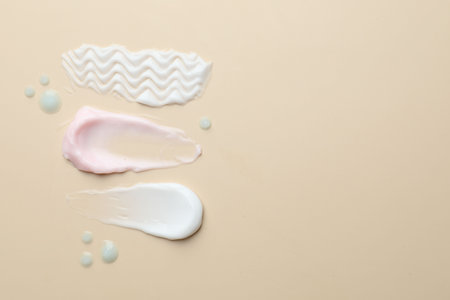 Samples of different cosmetic products on beige background, flat lay. Space for textの写真素材