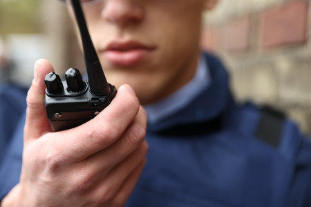 Police officer with radio on city street, closeupの写真素材