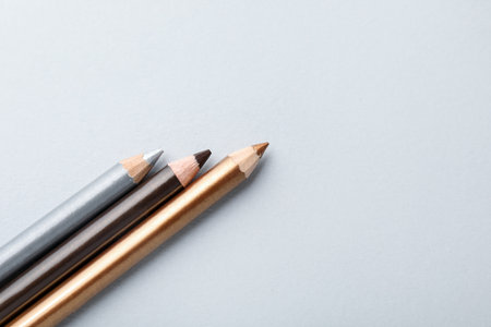 Colorful eye pencils on light background, flat lay. Space for textの写真素材