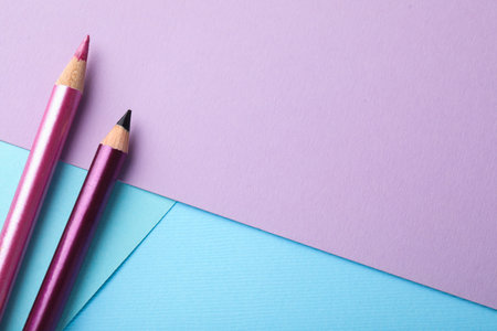 Colorful eye pencils on color background, flat lay. Space for textの写真素材