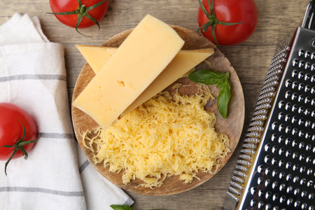 Grated cheese, grater and products on wooden table, flat layの写真素材
