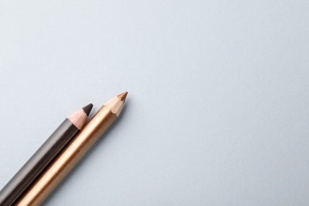 Colorful eye pencils on light background, flat lay. Space for textの写真素材