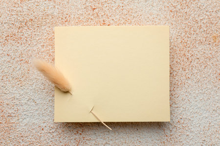 Blank card on textured beige background, top view. Mockup for design