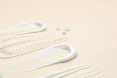 Samples of different cosmetic products on beige background, closeup. Space for text