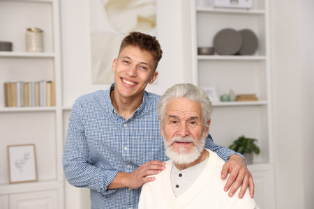 Happy son hugging his father at homeの写真素材